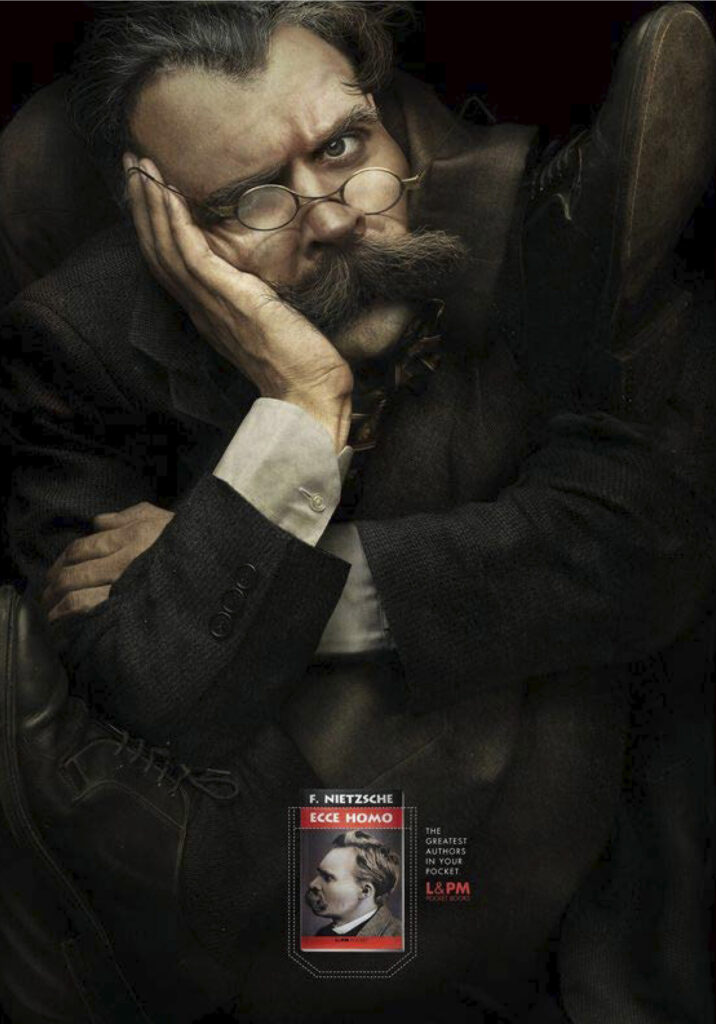 Anúncio publicitário Editora L&PM. Texto: "The greatest authors in your pocket." Imagem: Homem parecendo Nietzsche apertado no campo do anúncio. Capa de livro Ecce Homo, F. Nietzsche.